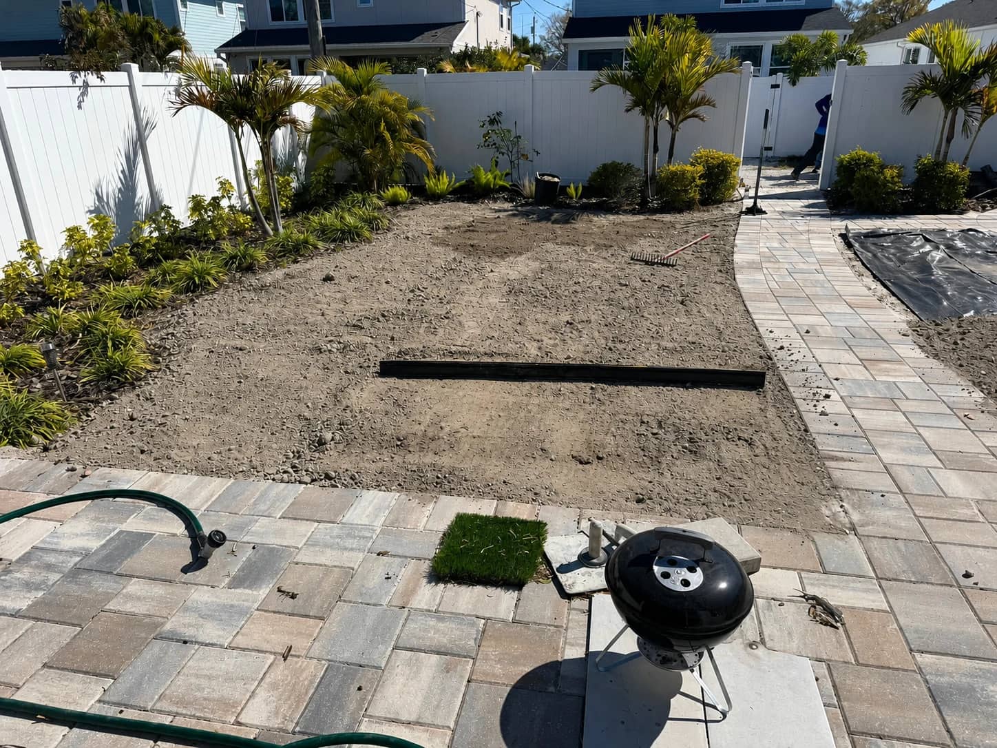 Before photo of an artificial turf installation area with the ground prepared for work.