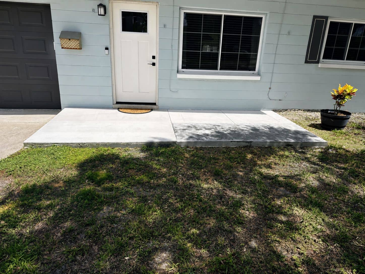 Finished concrete pad and walkway poured at the front entry of a home.