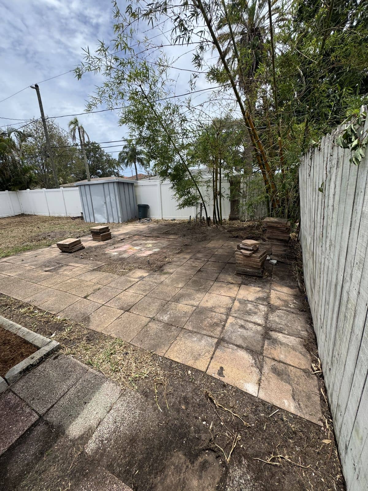 Cleared backyard paver patio with debris removed and the whole space tidied up.